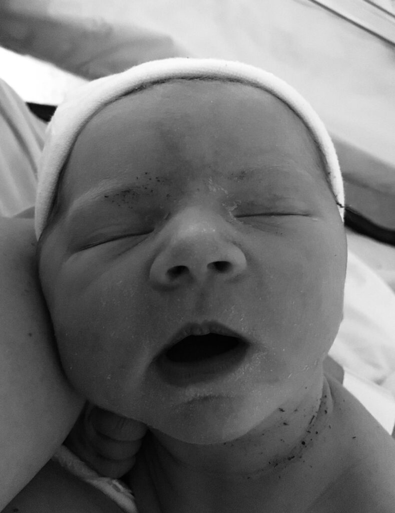 Newborn baby wearing white hat